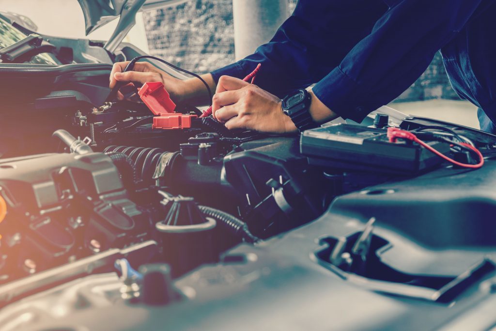 Mechanic is using a tool to check the status of the Battery
