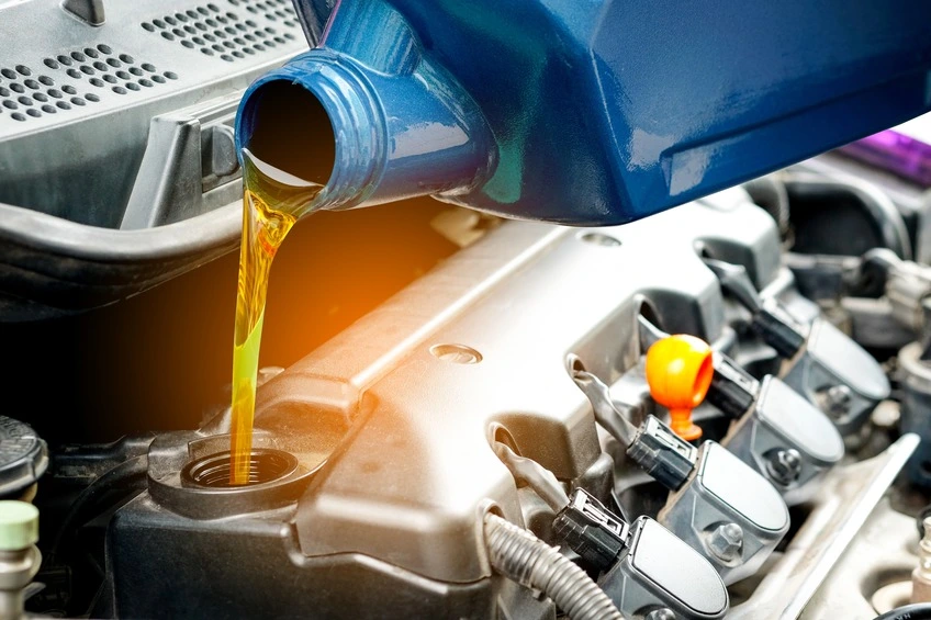 Close-up of engine oil being poured into a car engine.