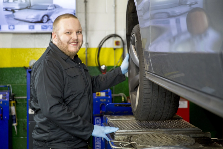 MOT Tester checking a wheel during an MOT Test